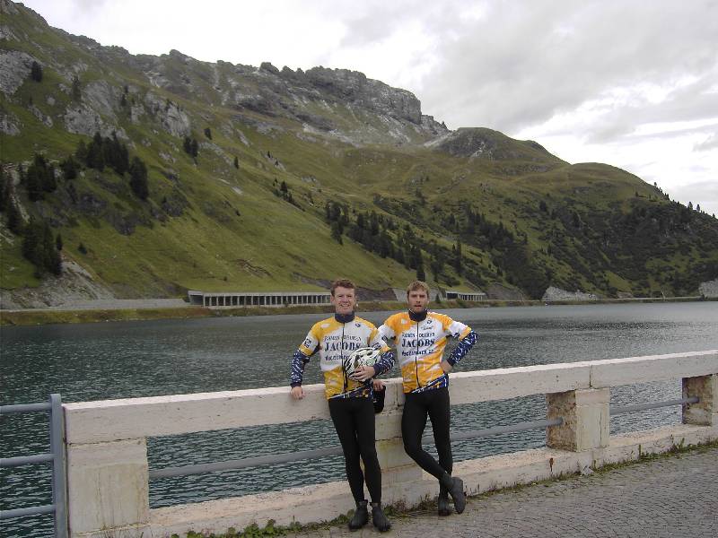 Wielertoeristen als toerist
Pit en Raf poseren als echte toeristen op de dam van het Lago di Fedaia en moeten daarna als tegendienst de fotografen, een Hollands koppel, fotograferen.
