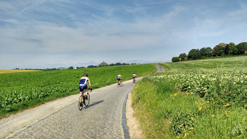 Op naar de Leeuw
Iedereen op weg naar de Leeuw op de bultige kasseien van de heirbaan.
